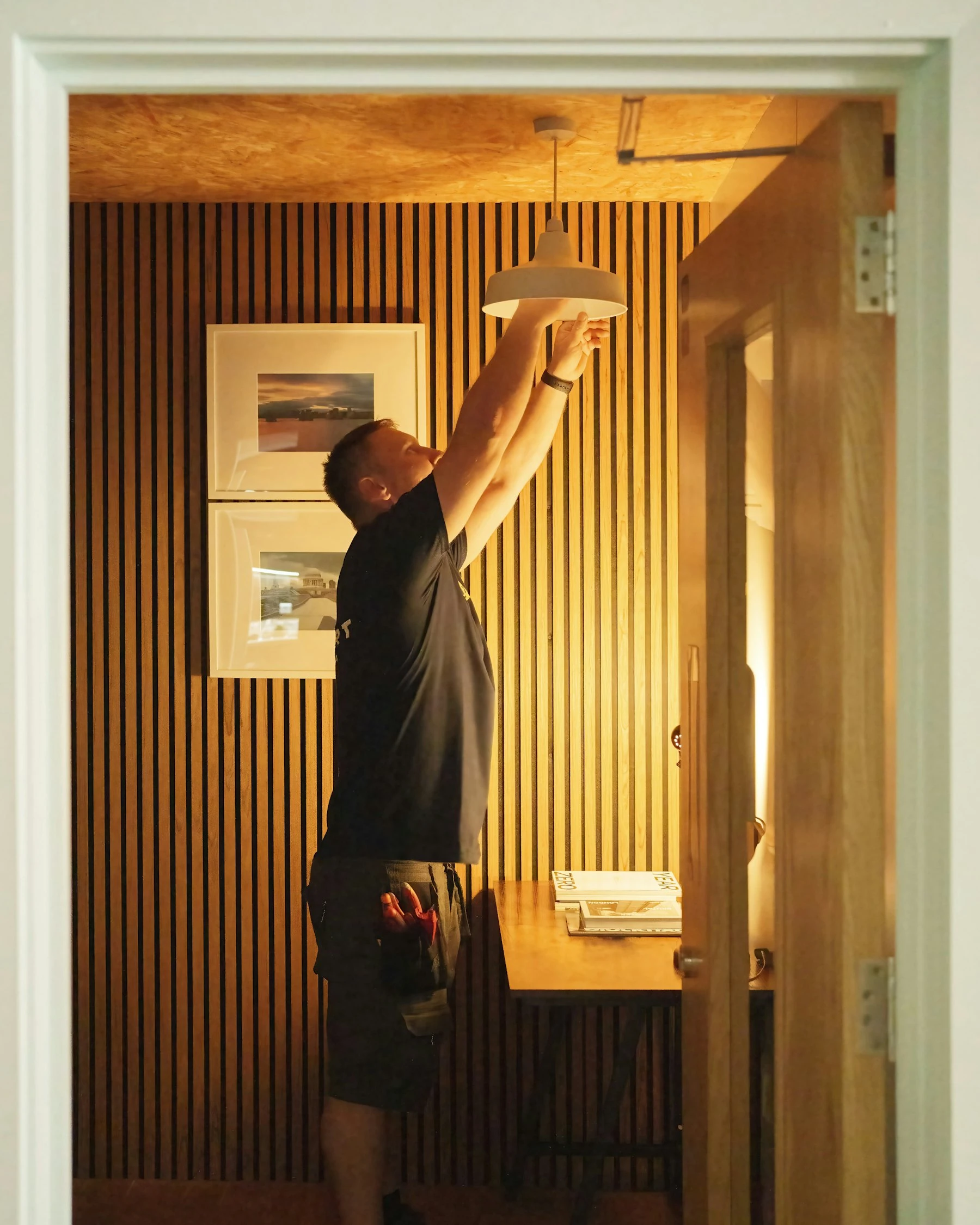 Electrician installing a pendant light in a finished home
